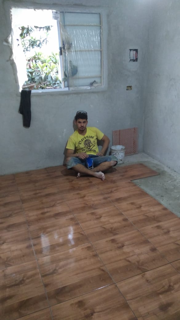Cômodo em obra com piso de madeira em instalação parcial