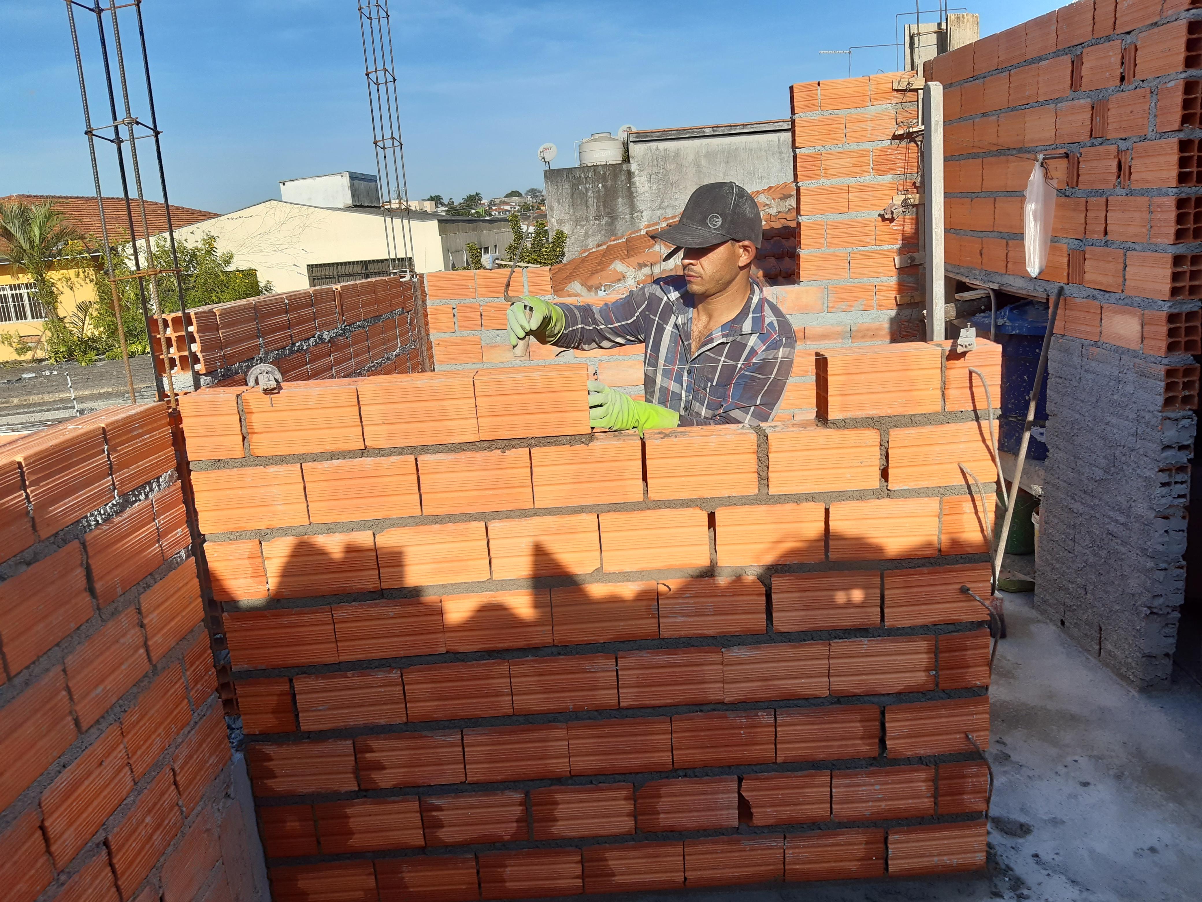 Levantamento de parede de tijolos cerâmicos vermelhos no terraço